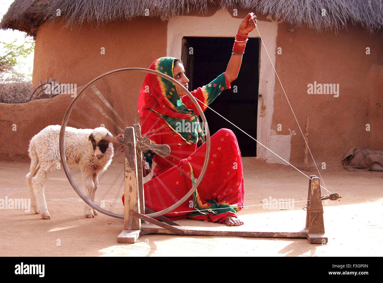 Donna al lavoro su ruota di filatura ; Bikaner ; Rajasthan ; India Foto Stock
