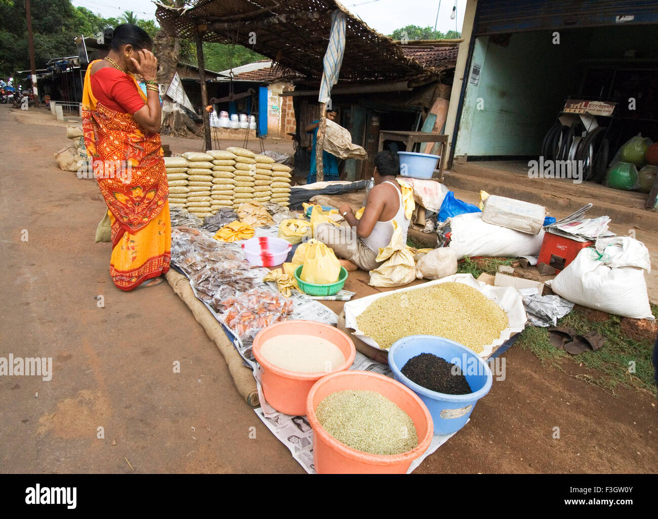 Drogheria ed una signora il consumatore nel bazar settimanale di villaggio kudal ; district Sindhudurga ; Maharashtra ; India Foto Stock