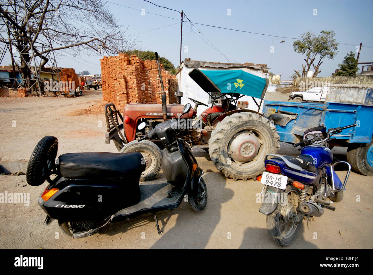 Uno scooter e moto e un trattore parcheggiato sul lato strada ; Dehradun ; Uttaranchal ; India Foto Stock