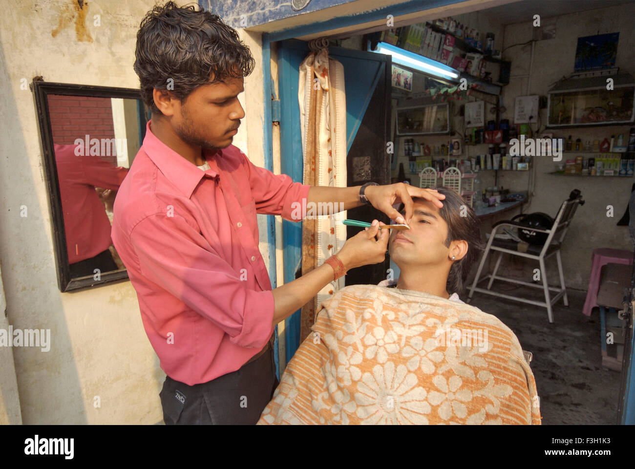Un giovane uomo di ottenere la sua barba rasata al Taj capelli e salone di bellezza ; Dehradun ; Uttaranchal ; India Foto Stock