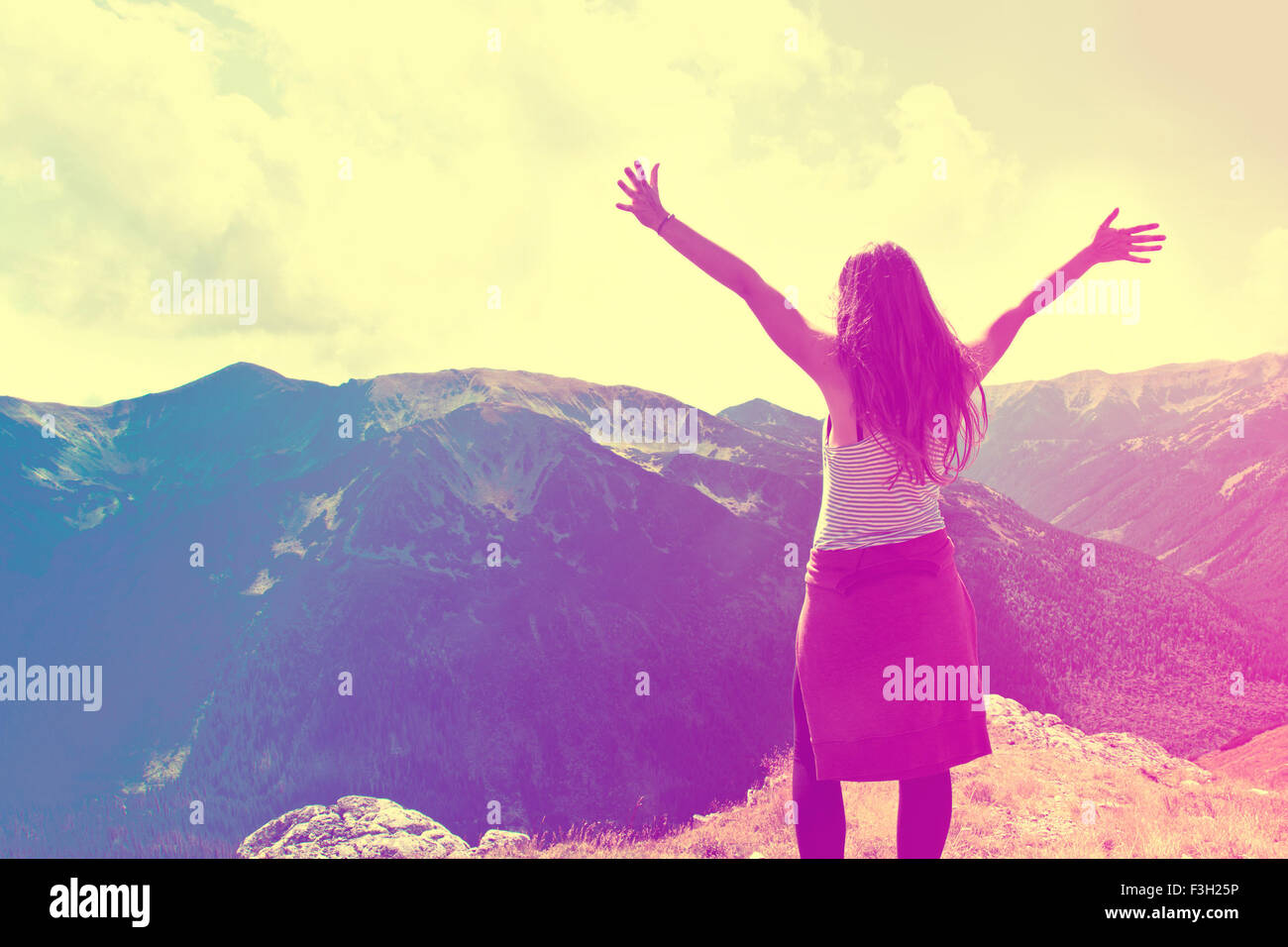 Felice ragazza adolescente sentire la libertà di montagne paesaggio. Vintage instagram foto. Foto Stock
