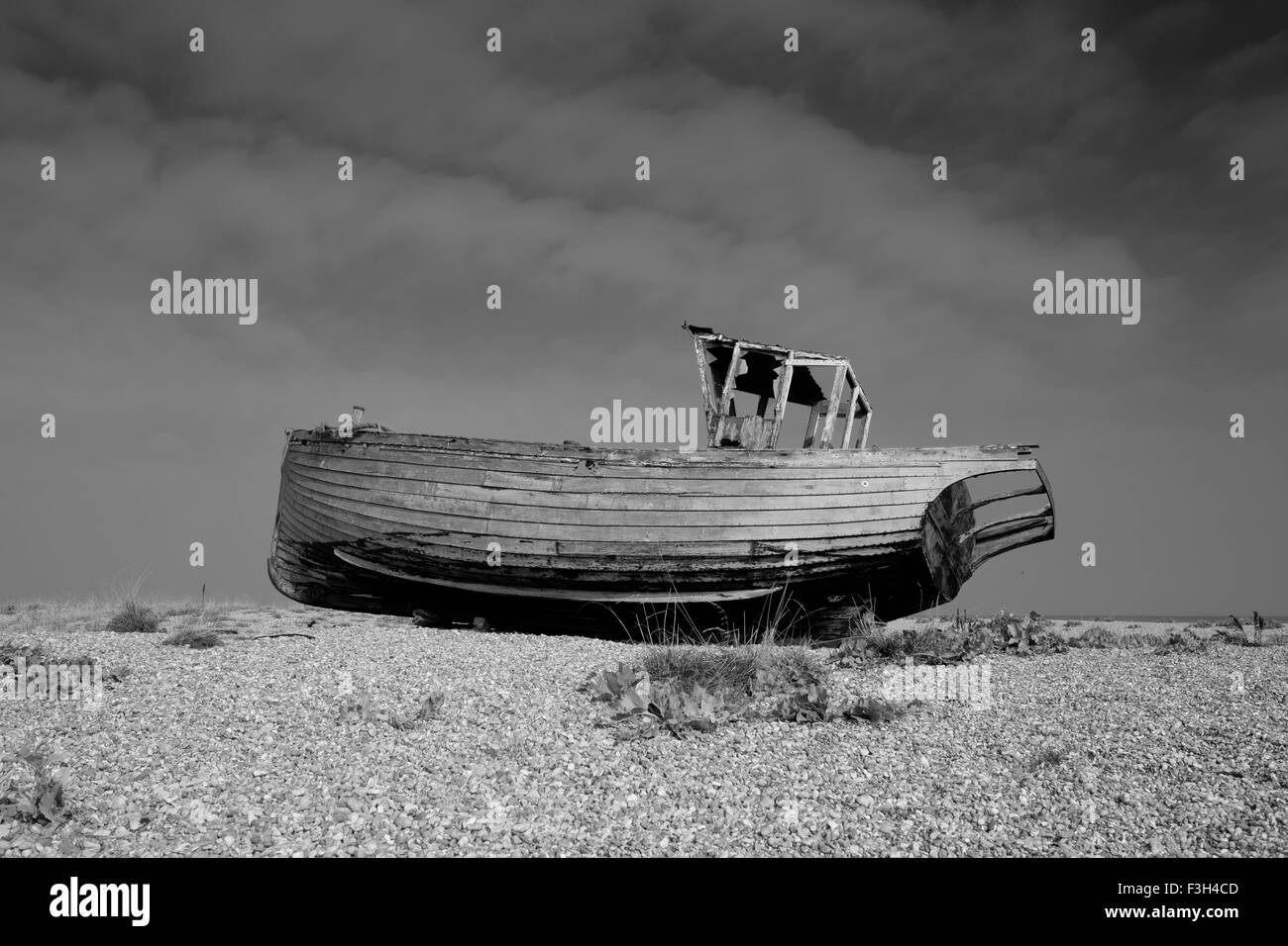 Una barca in disuso sulla spiaggia di ciottoli a Dungeness vicino a Lydd nel Kent Foto Stock