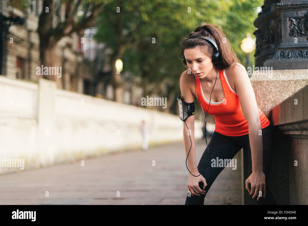 Femminile di indossare le cuffie per una pausa su Riverside Foto Stock