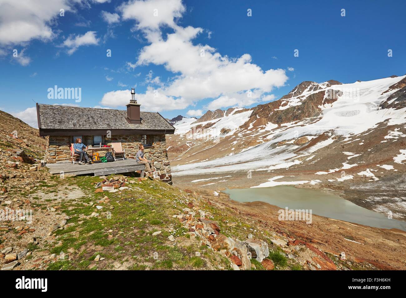 Giovani escursionismo giovane prendendo una pausa al di fuori di capanna, Funivie Ghiacciai Val Senales, Val Senales Alto Adige - Italia Foto Stock