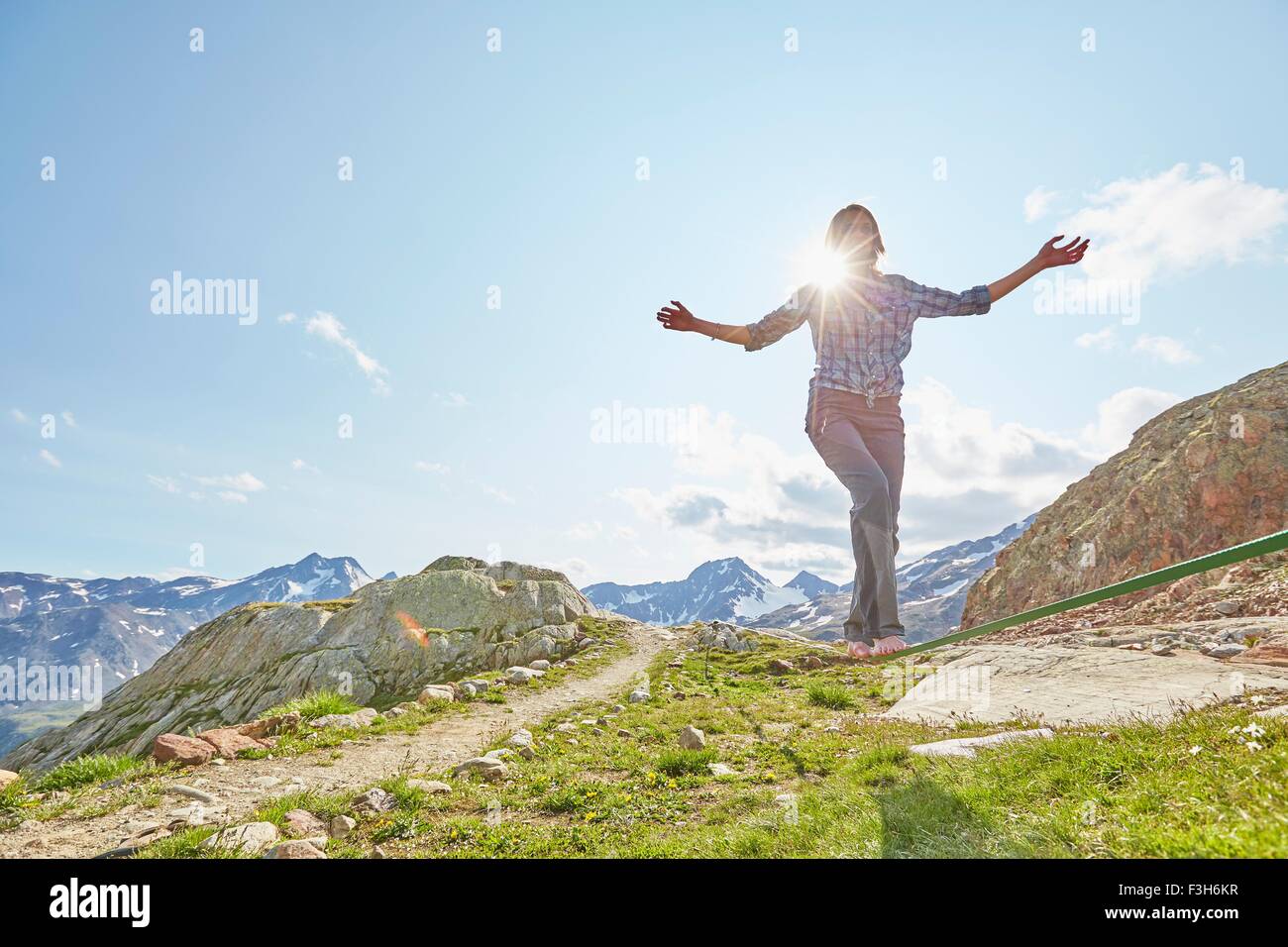 Giovane donna in equilibrio su slackline in Val Senales ghiacciaio della Val Senales, Alto Adige, Italia Foto Stock