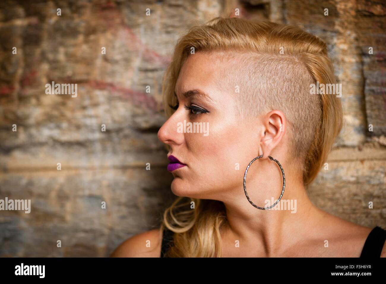 Ritratto di metà donna adulta con radere i capelli biondi guardando lateralmente Foto Stock