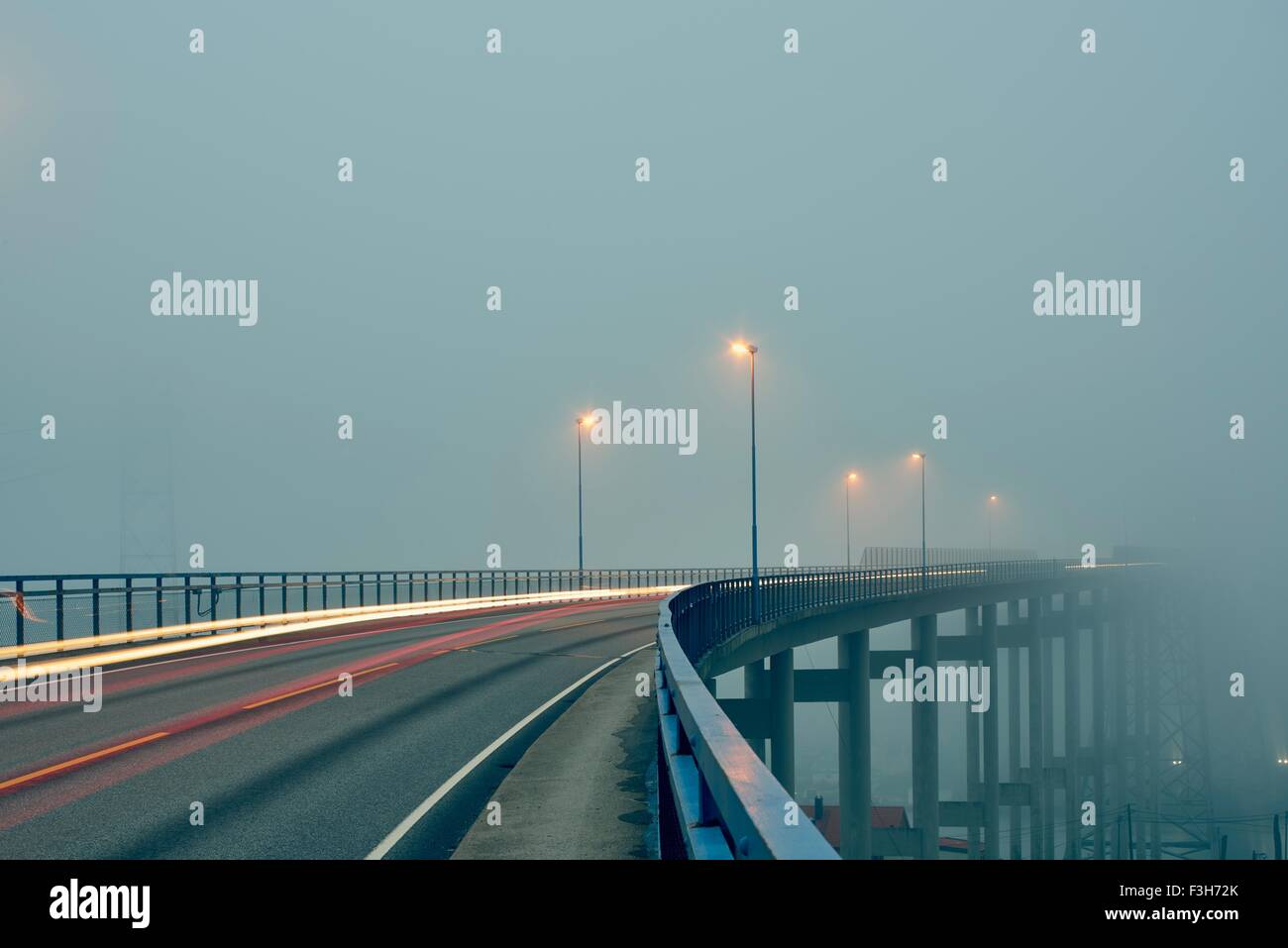 Diminuzione prospettiva di sentieri di luce su misty strada sopraelevata illuminato da luci di strada, Haugesund, Rogaland County, Norvegia Foto Stock