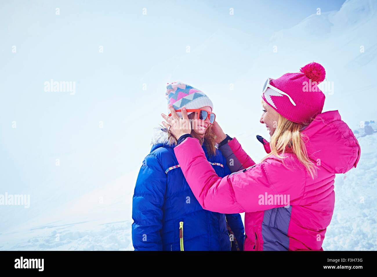 Madre aiutare figlia con occhiali da sole, Chamonix, Francia Foto Stock