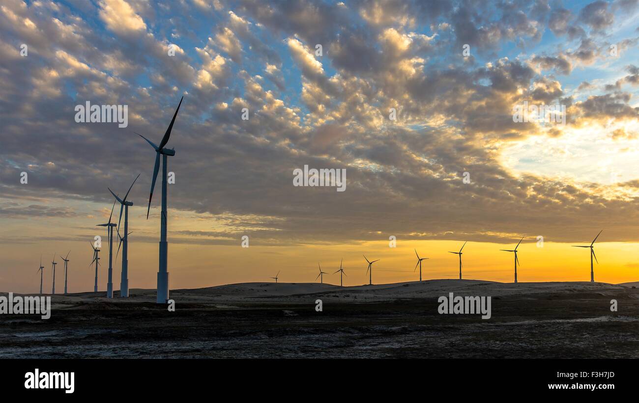 Le turbine eoliche in una fila su wind farm contro il cielo drammatico Foto Stock