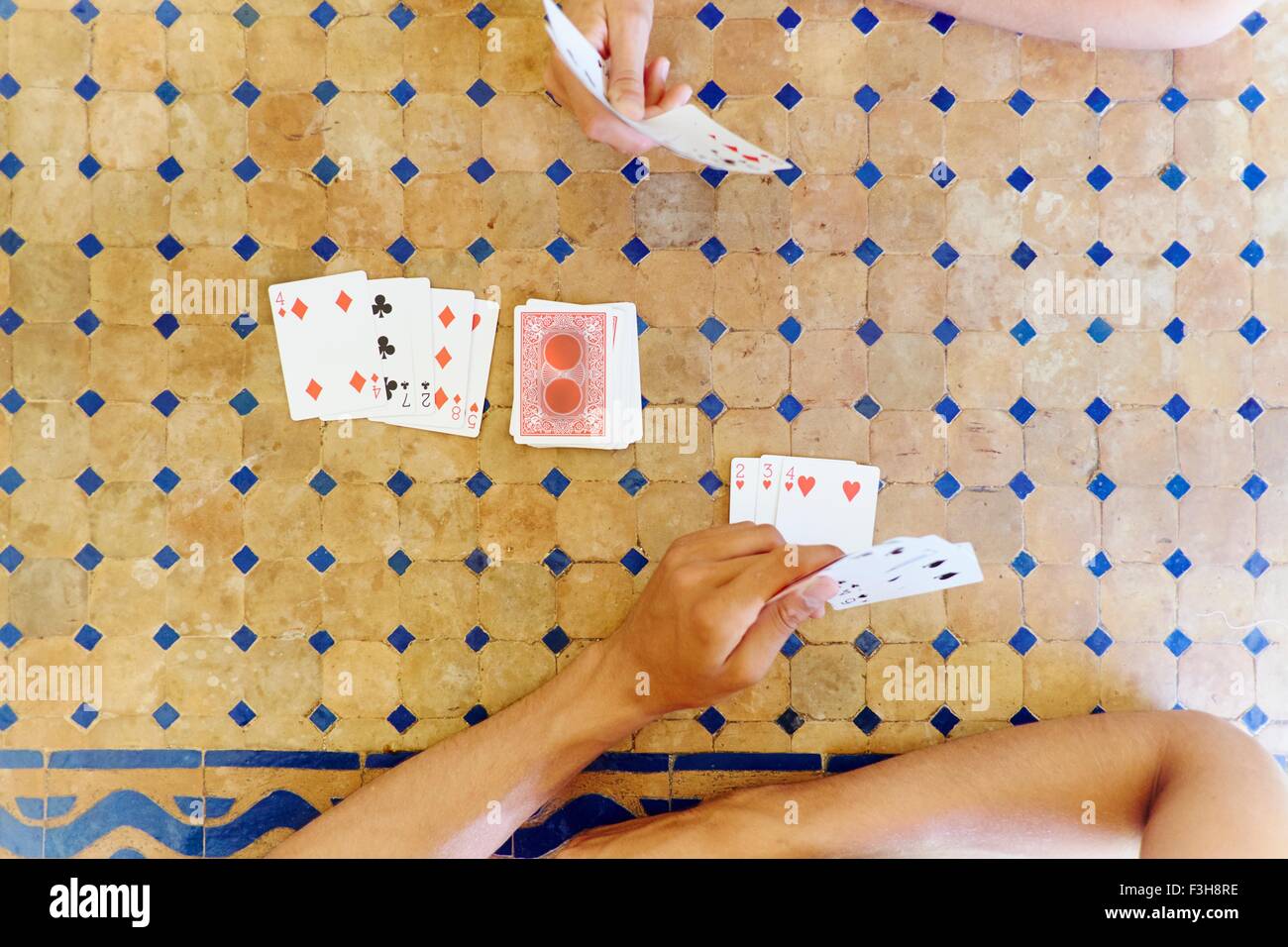 Overhead shot ritagliata della donna matura e figlio giocando a carte in tavola Foto Stock