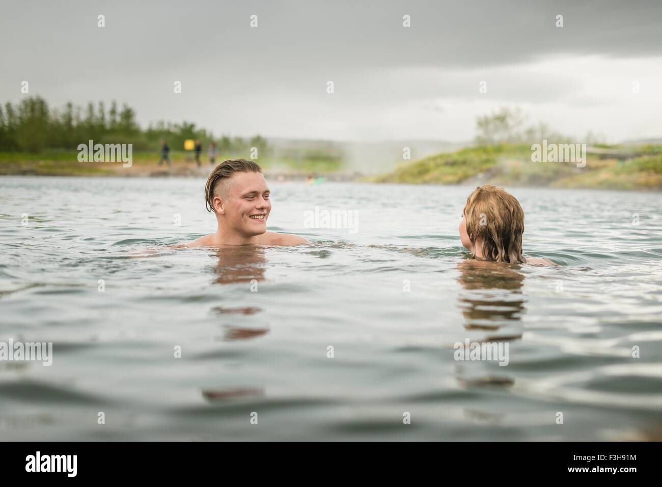 Coppia giovane rilassante in Laguna Segreta primavera calda (Gamla Laugin), Fludir, Islanda Foto Stock
