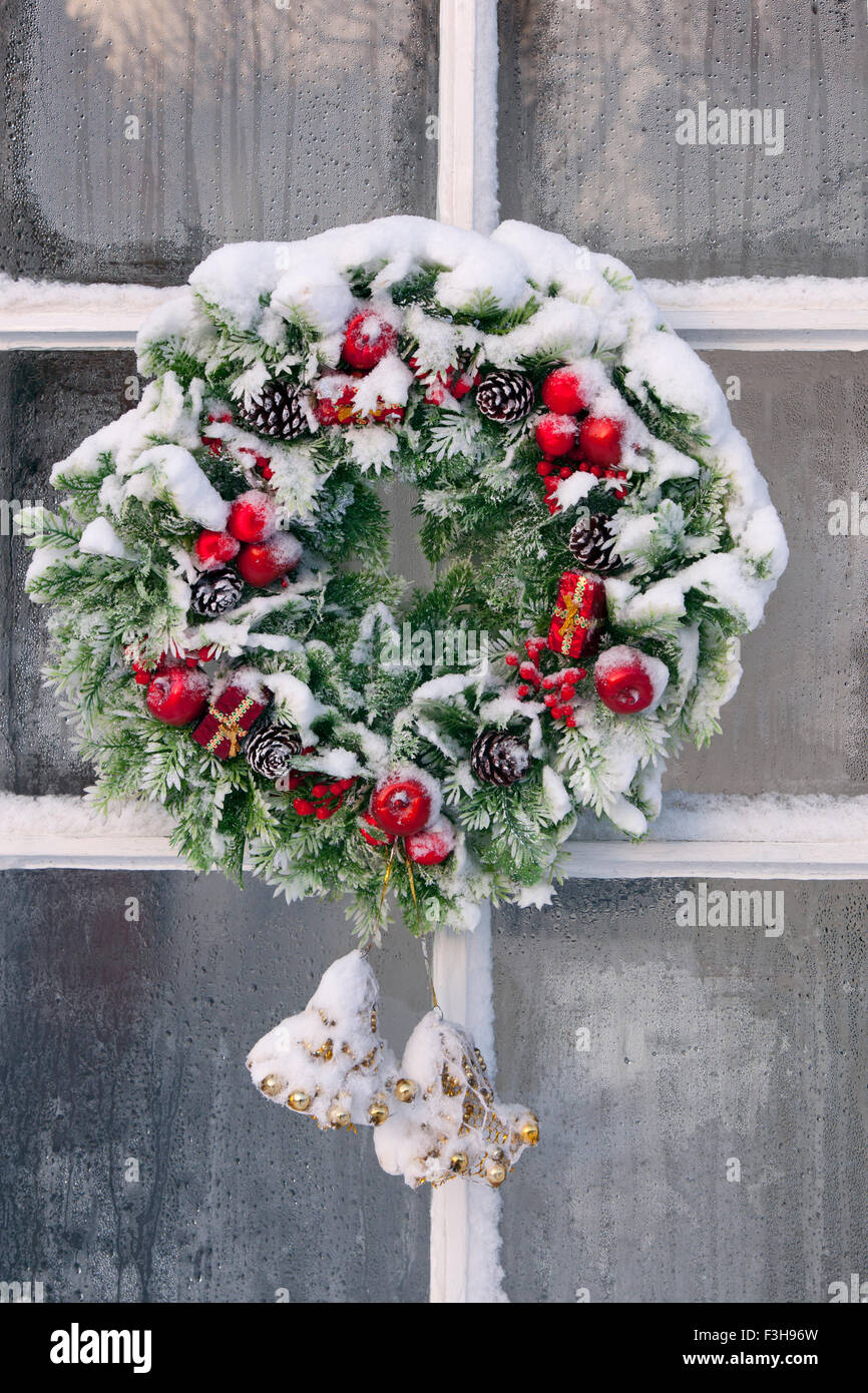 Ghirlanda di Natale sulla porta cottage in snow Foto Stock