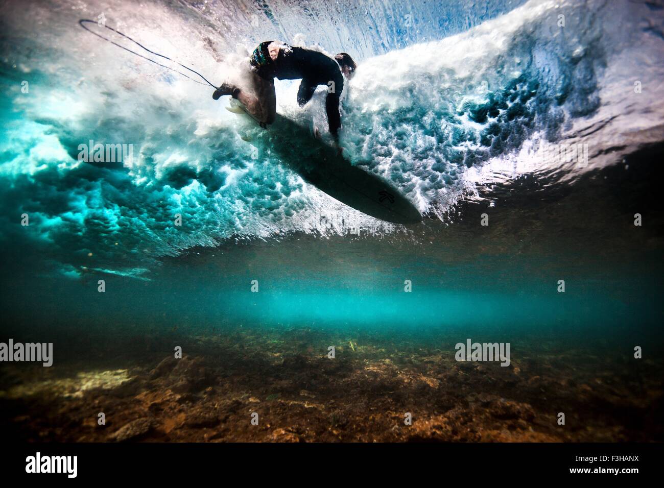 Vista subacquea del surfer cade in acqua dopo la cattura di un'onda su una scogliera poco profonda in Bali, Indonesia Foto Stock