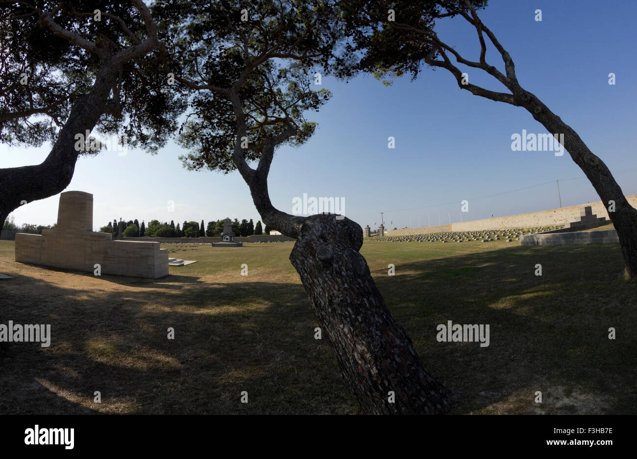 Tree ombre sulla Croce includono lastra (sinistra) e ampia vista del paesaggio architettonico elementi del cimitero CWGC, Limnos. Foto Stock