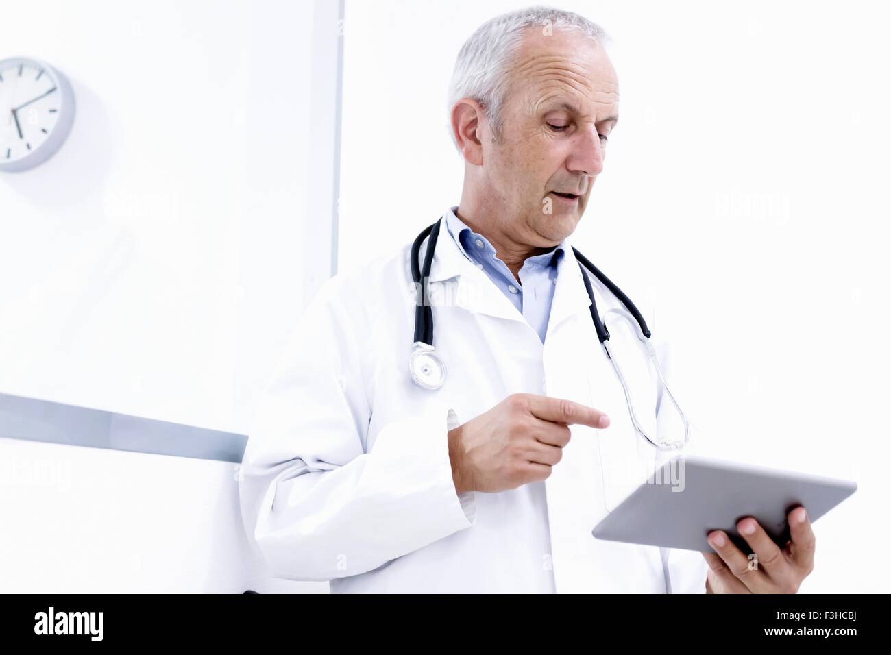 Medico maschio guardando a tavoletta digitale Foto Stock