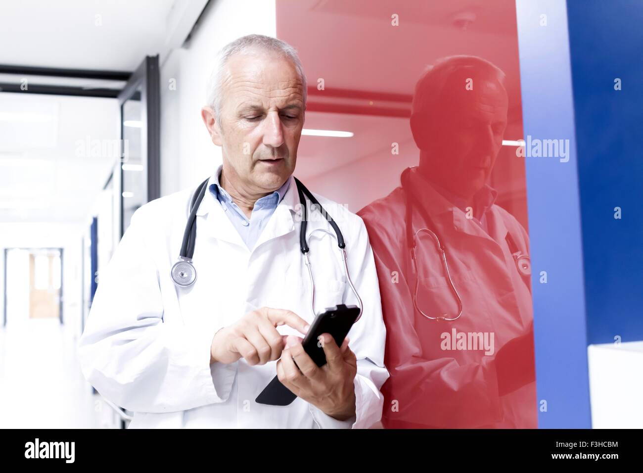 Medico maschio utilizza lo smartphone Foto Stock