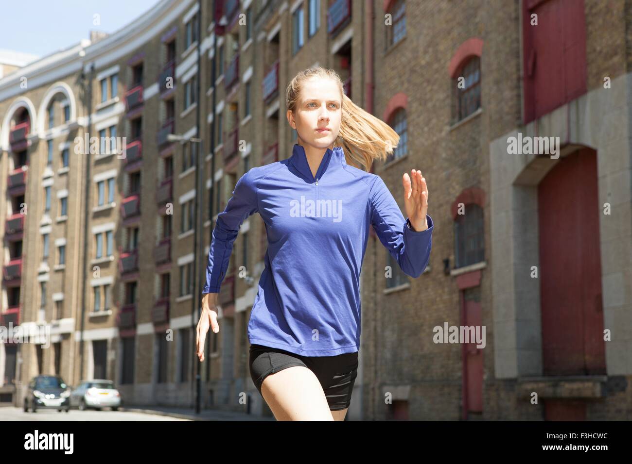 Runner jogging passato building block, Wapping, Londra Foto Stock
