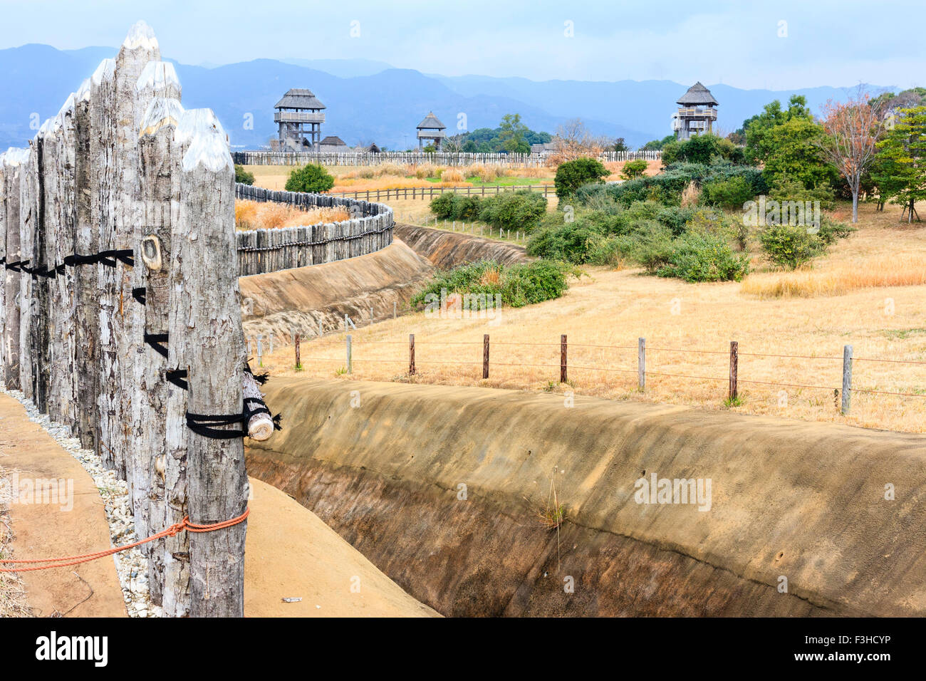 Parco Yoshinogari, Giappone. Yayoi insediamento ricostruito. Minami no Mura, villaggio del sud. Muro e fossato a Minaminaikaku, righelli, area e le torri di guardia. Foto Stock