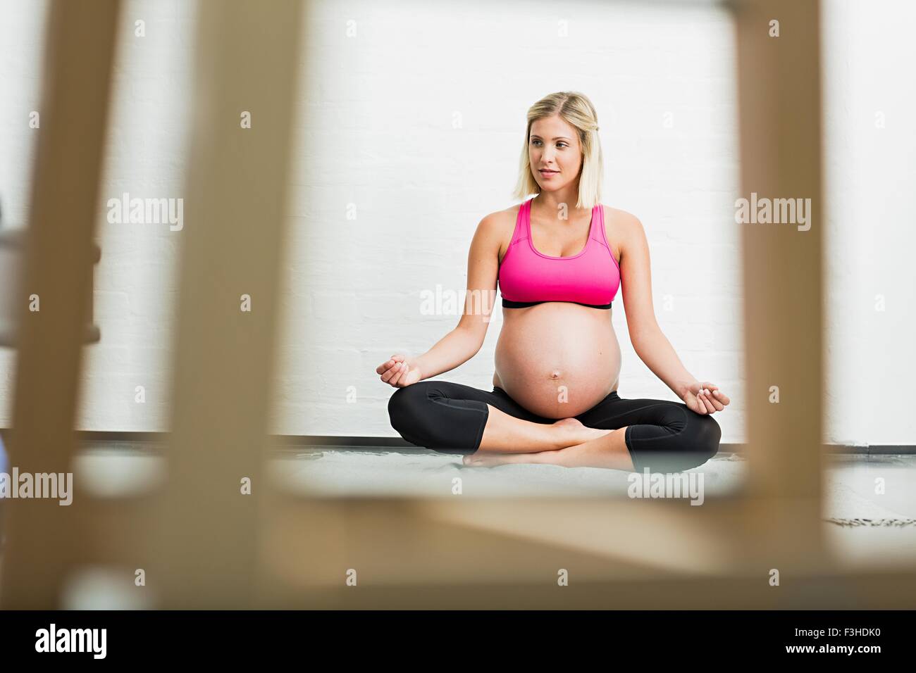 Pieno termine di gestazione giovane donna a praticare yoga Foto Stock