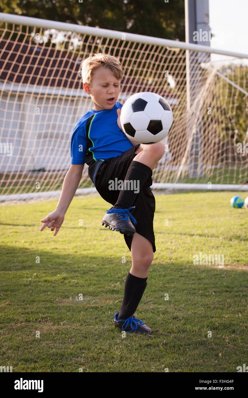 Ragazzo giocando keepy uppy con il calcio del passo Foto Stock