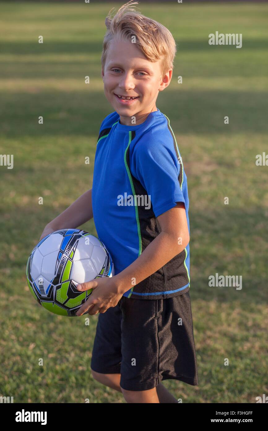 Ritratto di Ragazzo giocatore di calcio calcio di contenimento sul campo di pratica Foto Stock