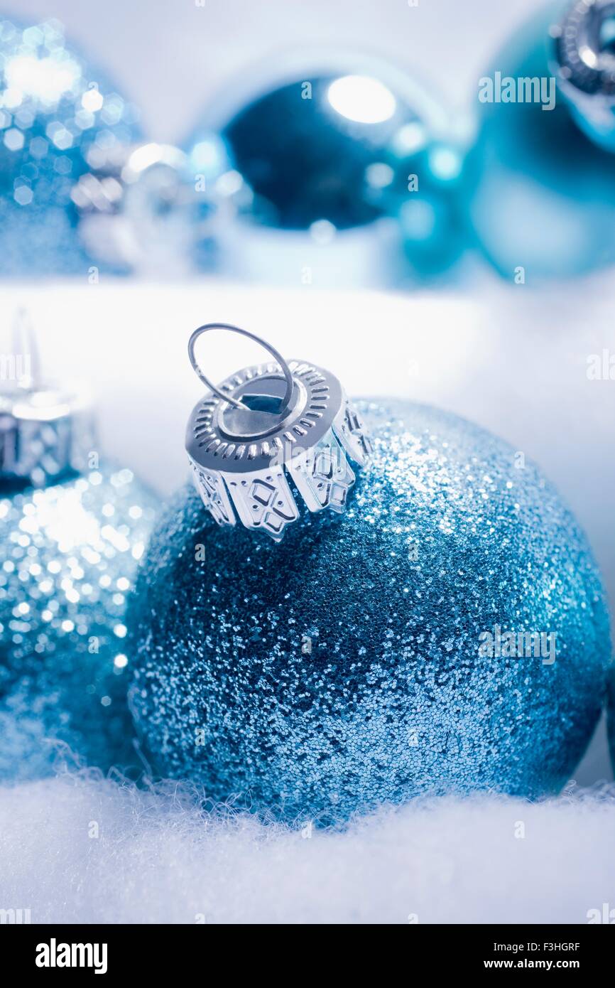 Ritagliato shot di blu scintillanti baubles di Natale nested è fake snow Foto Stock