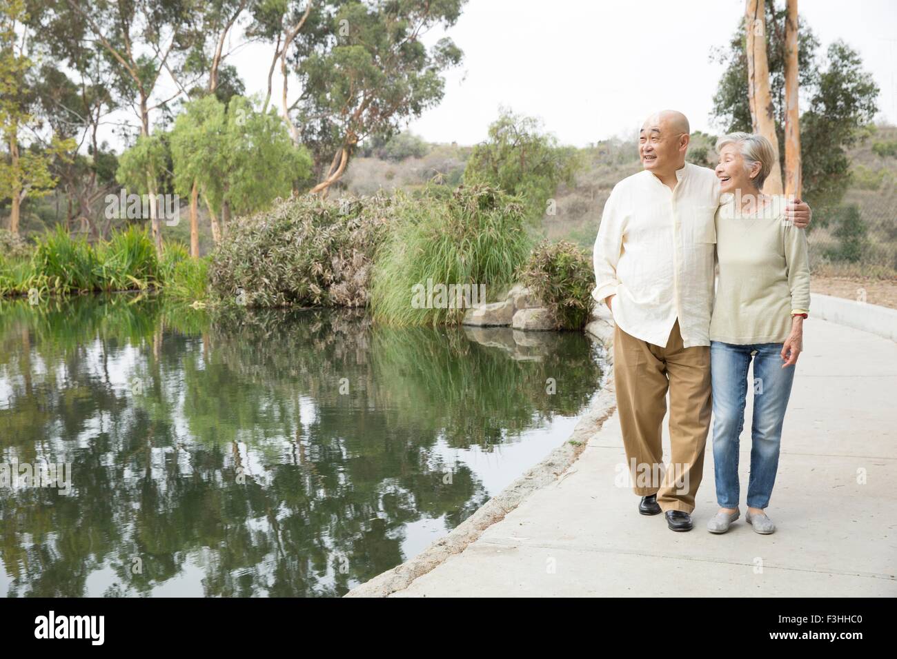 Coppia senior camminando accanto al lago Foto Stock