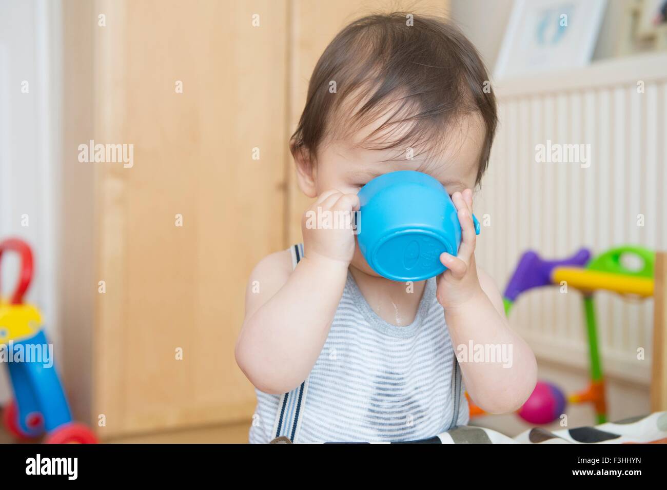 Giovane bambino neonato 7 mesi di bere dalla verde lime allattamento cup  Flacone Bicchiere mug mostra avanzate competenze di motore Foto stock -  Alamy