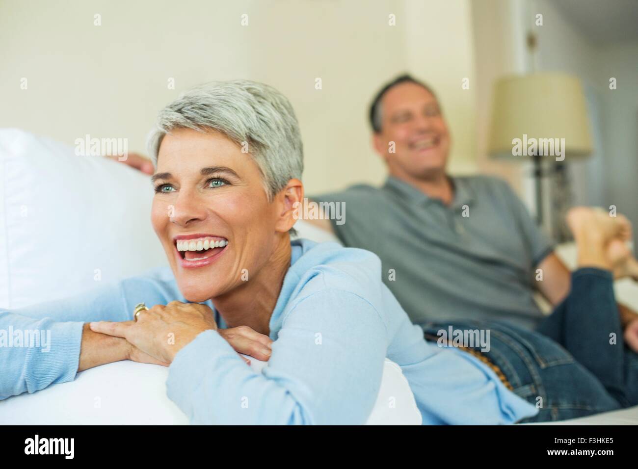 Coppia matura ridendo e rilassante sul divano Foto Stock