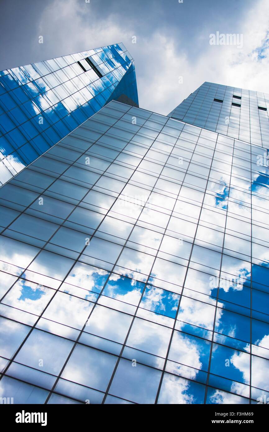 Immagine speculare del cielo blu e nuvole in vetro frontale grattacielo Foto Stock