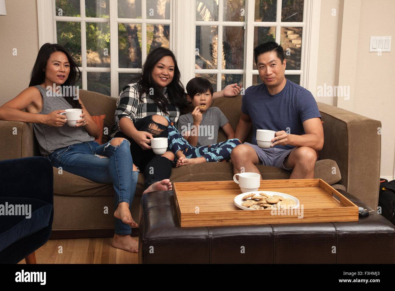 Famiglia con bambino rilassante sul divano e guardare la TV Foto Stock