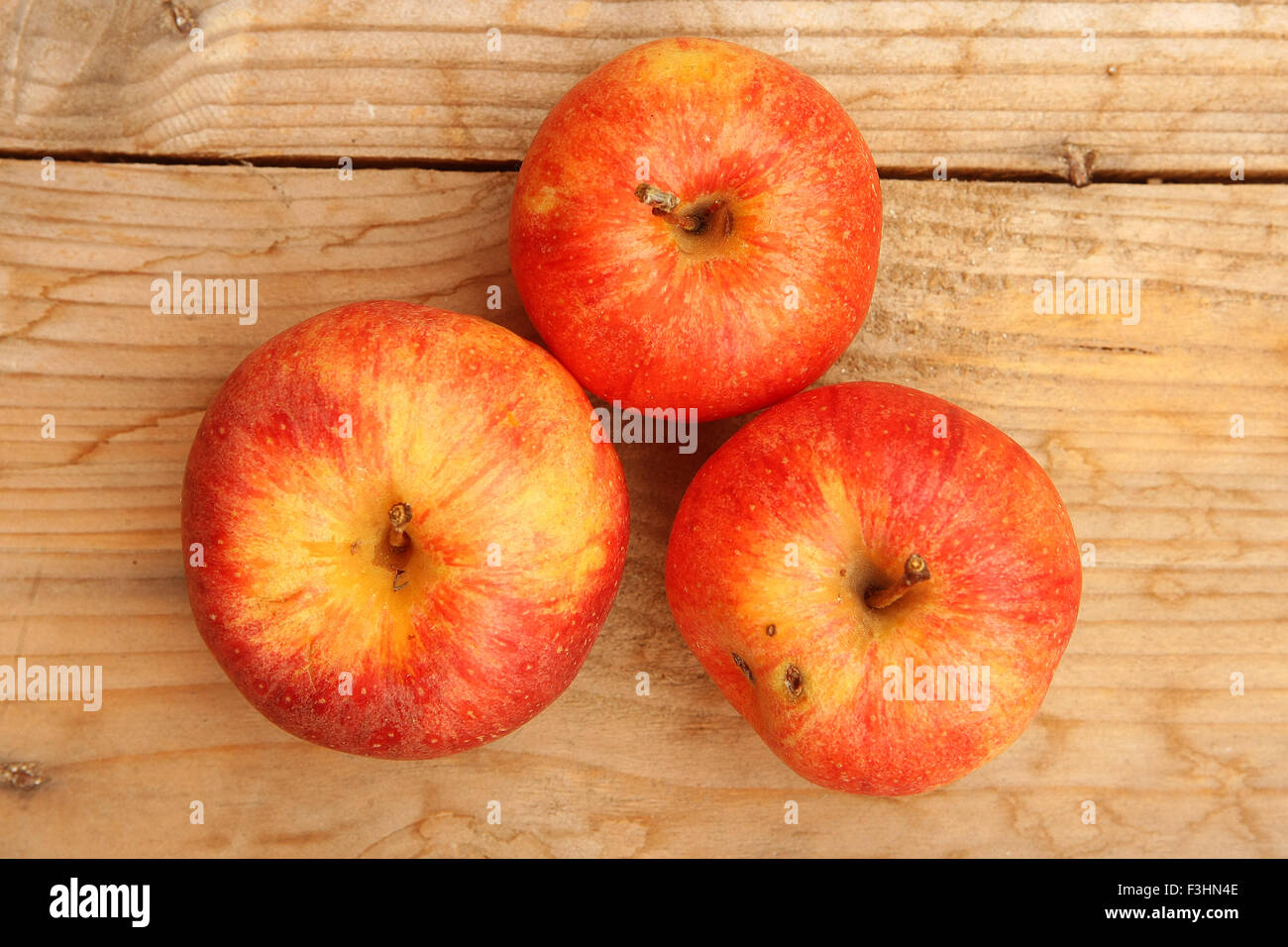 Tre Mele rosse su una tavola di legno.effetto vintage Foto Stock