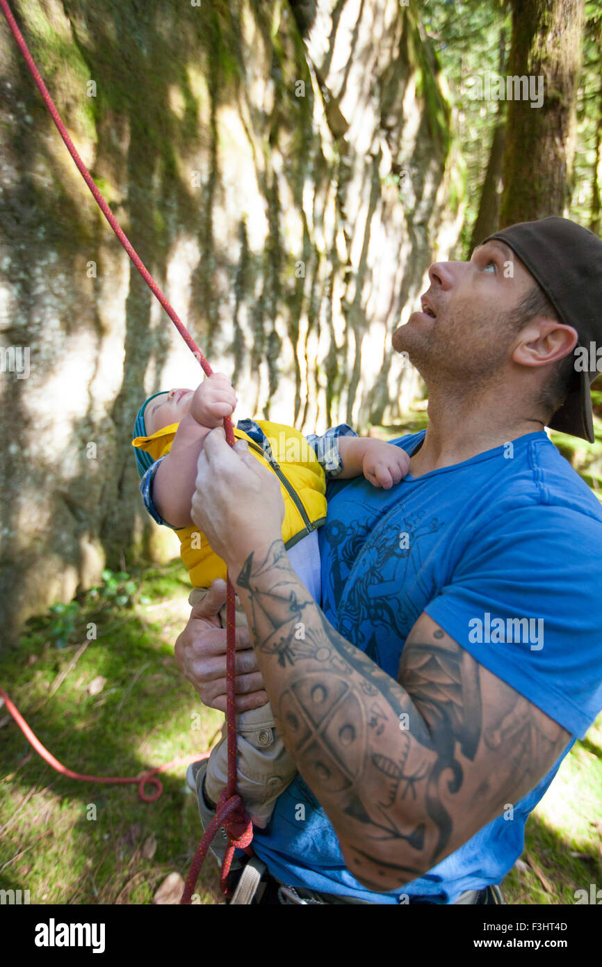 Un padre e suo figlio per raggiungere una fune di arrampicata mentre cercano fino in corrispondenza di una via ferrata. Foto Stock