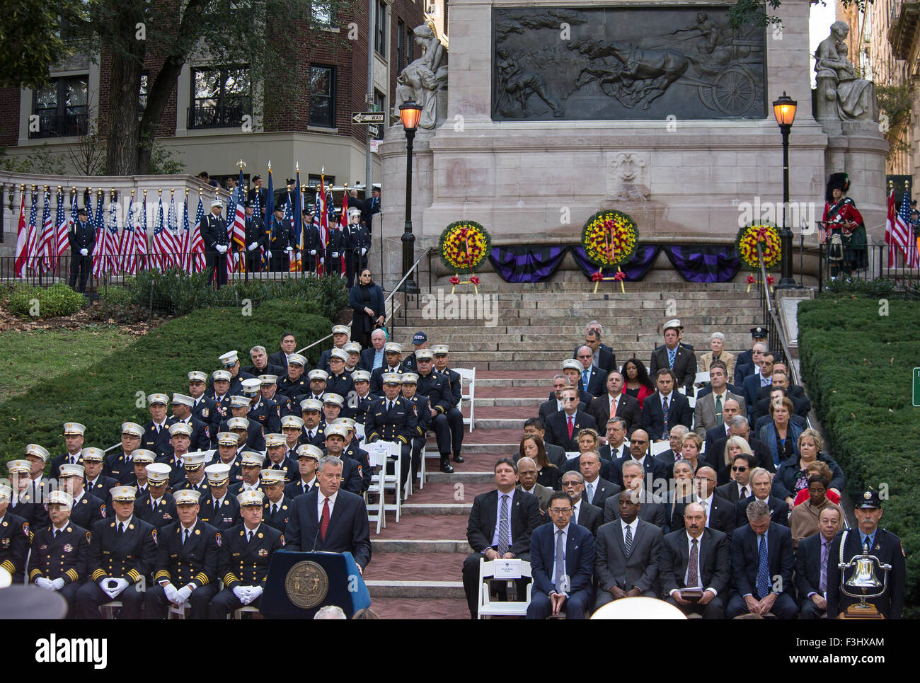 New York, Stati Uniti. 07 ott 2015. FDNY capi (sinistra) e autorità civili (a destra) sono seduti sui gradini che conducono a Vigili del Fuoco's Memorial come sindaco de Blasio (centro) eroga un discorso. Sindaco di Bill de Blasio e NYC Fire Commissario Daniel Nigro uniti con FDNY ufficiali e le famiglie dei caduti di recente presso i vigili del fuoco's Memorial in Riverside Park per un tributo annuale alla memoria della città partì di vigili del fuoco, del passato e del presente. Credito: Albin Lohr-Jones/Pacific Press/Alamy Live News Foto Stock