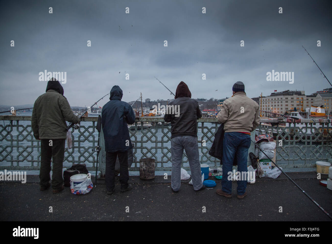 I pescatori in piedi sul ponte Galata ad Istanbul in Turchia la pesca Foto Stock