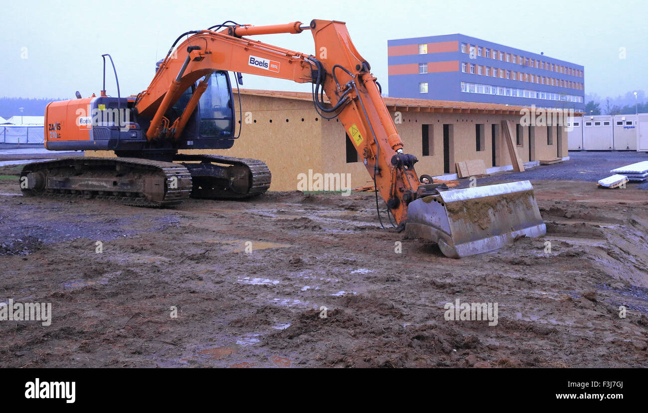 Halberstadt, Germania. Il 7 ottobre, 2015. Un escavatore su un sito di costruzione per un'estensione alla centrale del centro di accoglienza per i richiedenti asilo (ZASt) a Halberstadt, Germania, 7 ottobre 2015. Un totale di 11 case di legno e di ulteriori contenitori di alloggio sono destinate a sostituire le tende al ZASt. Il 27 x 11 metri edifici in legno può ospitare circa 550 persone. La costruzione è dovuto essere completato entro la fine di novembre. Fino ad ora, circa 700 ha vissuto sotto le tende presso il sito ZASt, a causa di una mancanza di spazio nelle case. Foto: Jens Wolf/dpa/Alamy Live News Foto Stock