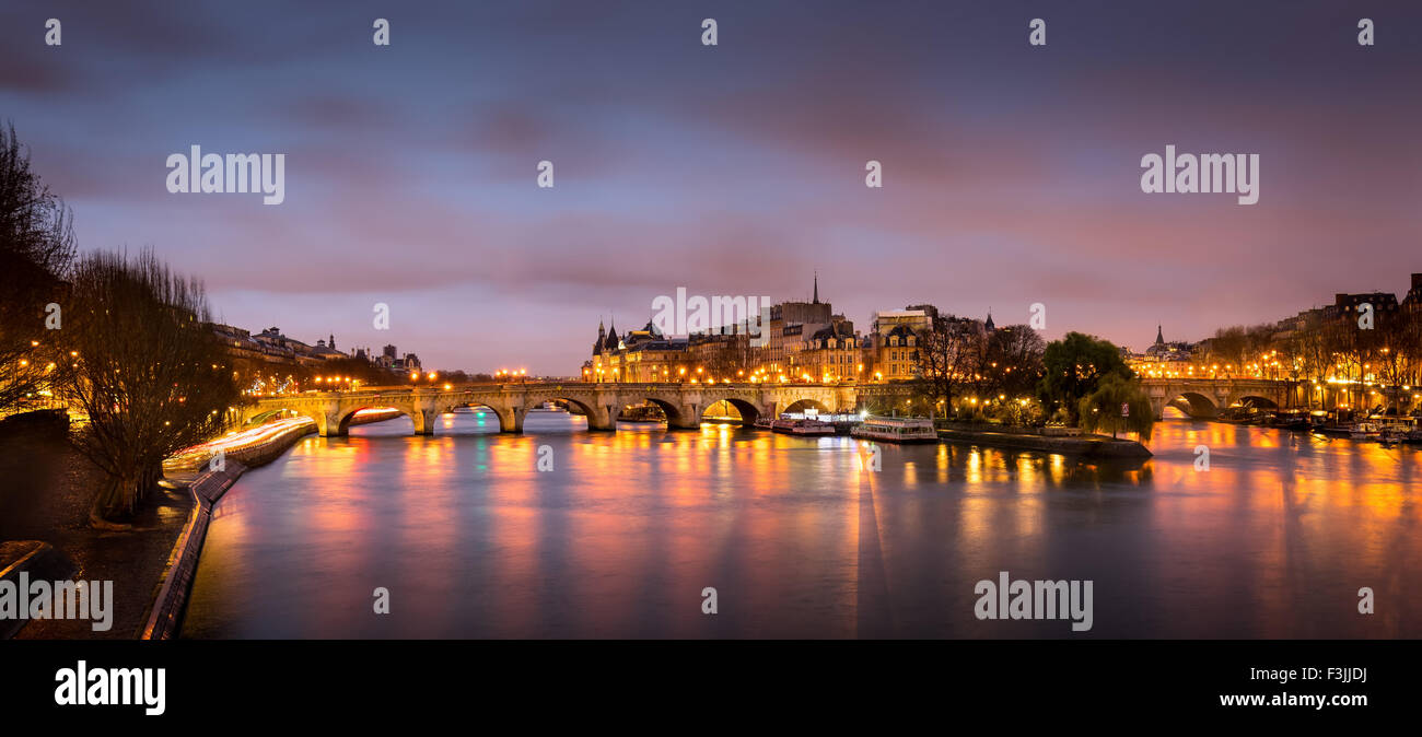 Sunrise nel cuore di Parigi, in Francia con Ile de la Cite e Pont Neuf. Un tranquillo Fiume Senna riflette le luci della citta'. Foto Stock