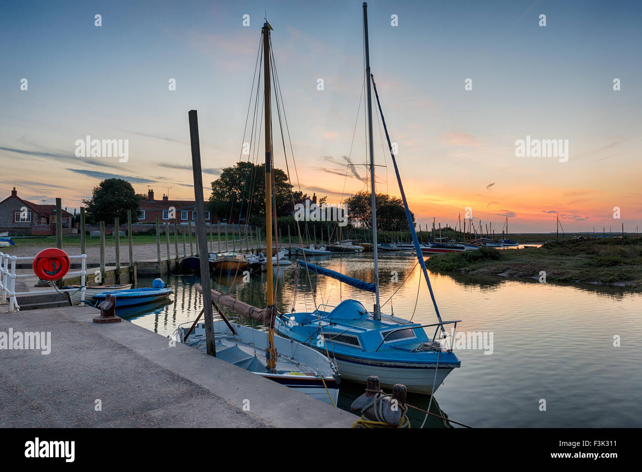 Tramonto su barche a vela ormeggiata in banchina a Blakeney sulla costa di Norfolk Foto Stock