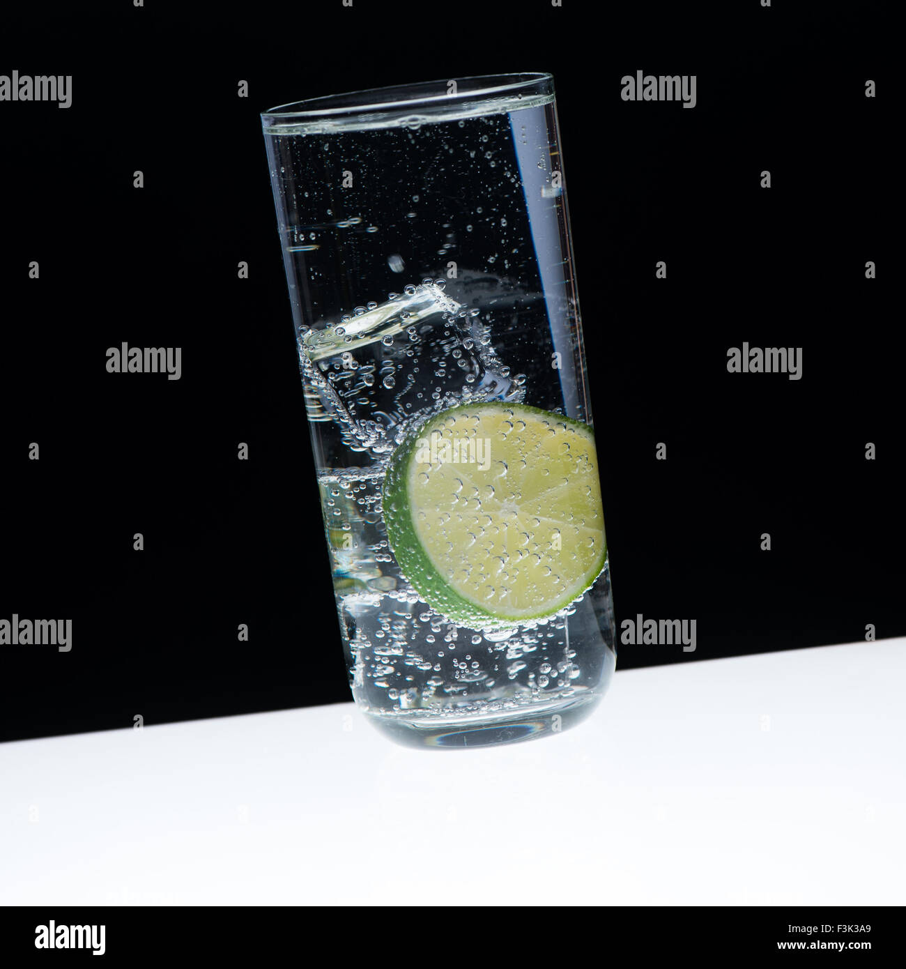 Vetro, ghiaccio, limone e Indian tonic/close-up con sfondo nero Foto Stock