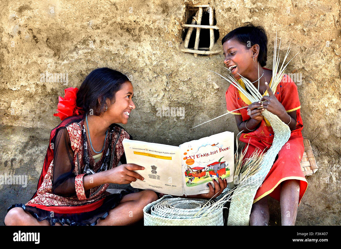 La gioia di imparare - una sorella maggiore imparare Inglese a sua sorella nella parte anteriore della loro casa. al remoto villaggio del Bengala Occidentale ho Foto Stock