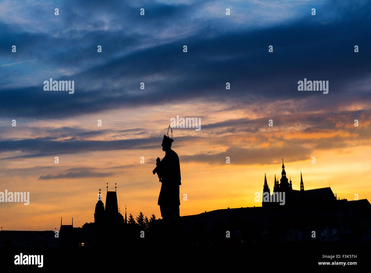 St; Giovanni di Nepomuk statua sul Ponte Carlo; Praga; Repubblica Ceca; con San Vito's cathadral e piccolo quartiere torre del ponte; Foto Stock
