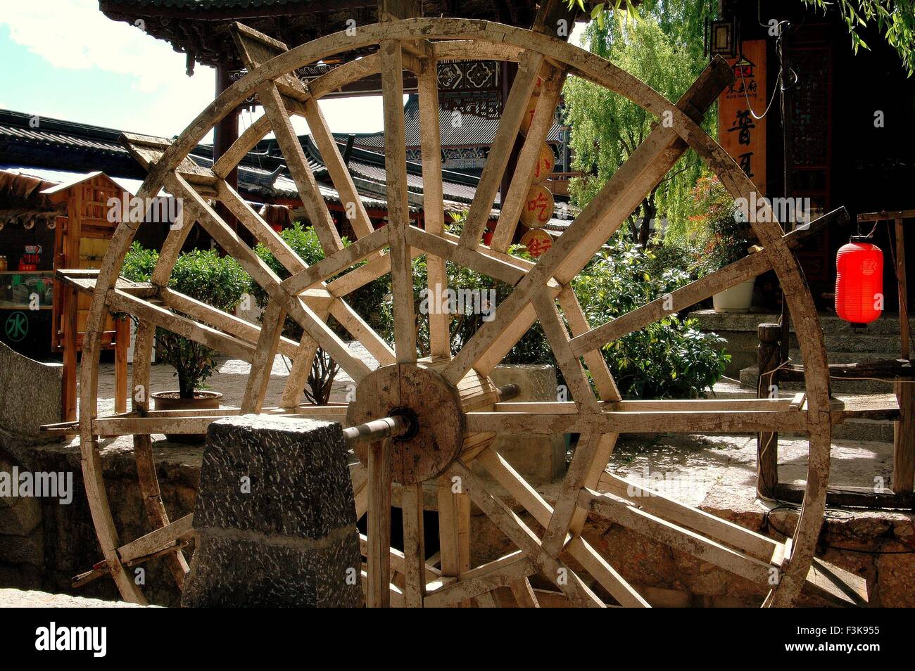 Lijiang, Cina: vecchia ruota di acqua di legno i bidoni in un piccolo ruscello nel centro storico della città Foto Stock