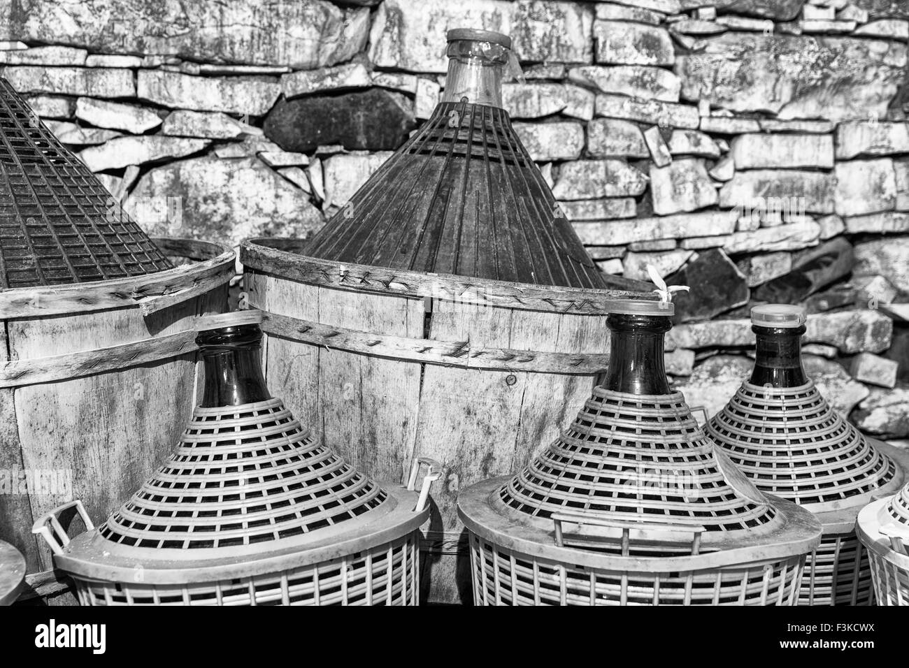 Damigiane di vino in una cantina in pietra. Foto Stock