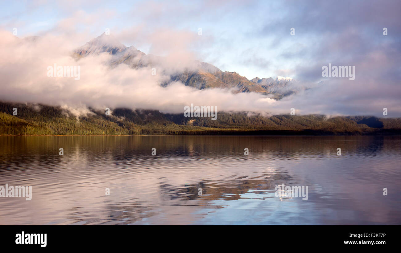 Tramonto dal Sullivan isola nel sud-est dell Alaska con la nebbia la cancellazione di rivelare picchi di montagna riflessa in acqua calma. Foto Stock