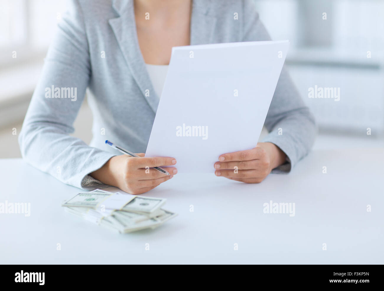 Close up di mani femminili con il denaro e la relazione fiscale Foto Stock