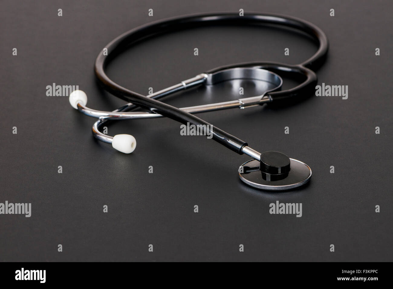 Uno stetoscopio per uso medico, visualizzato su una tavola nera Foto Stock