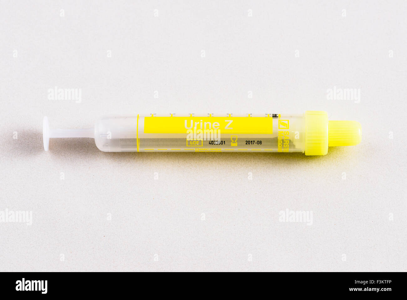 Un giallo fiala farmaceutica per uso medico, visualizzato su un tavolo bianco Foto Stock