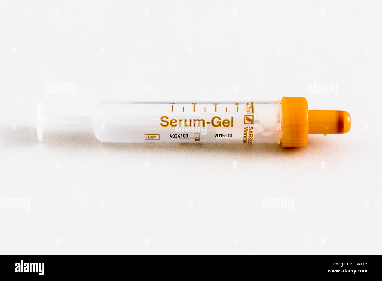 Un arancione fiala farmaceutica per uso medico, visualizzato su un tavolo bianco Foto Stock