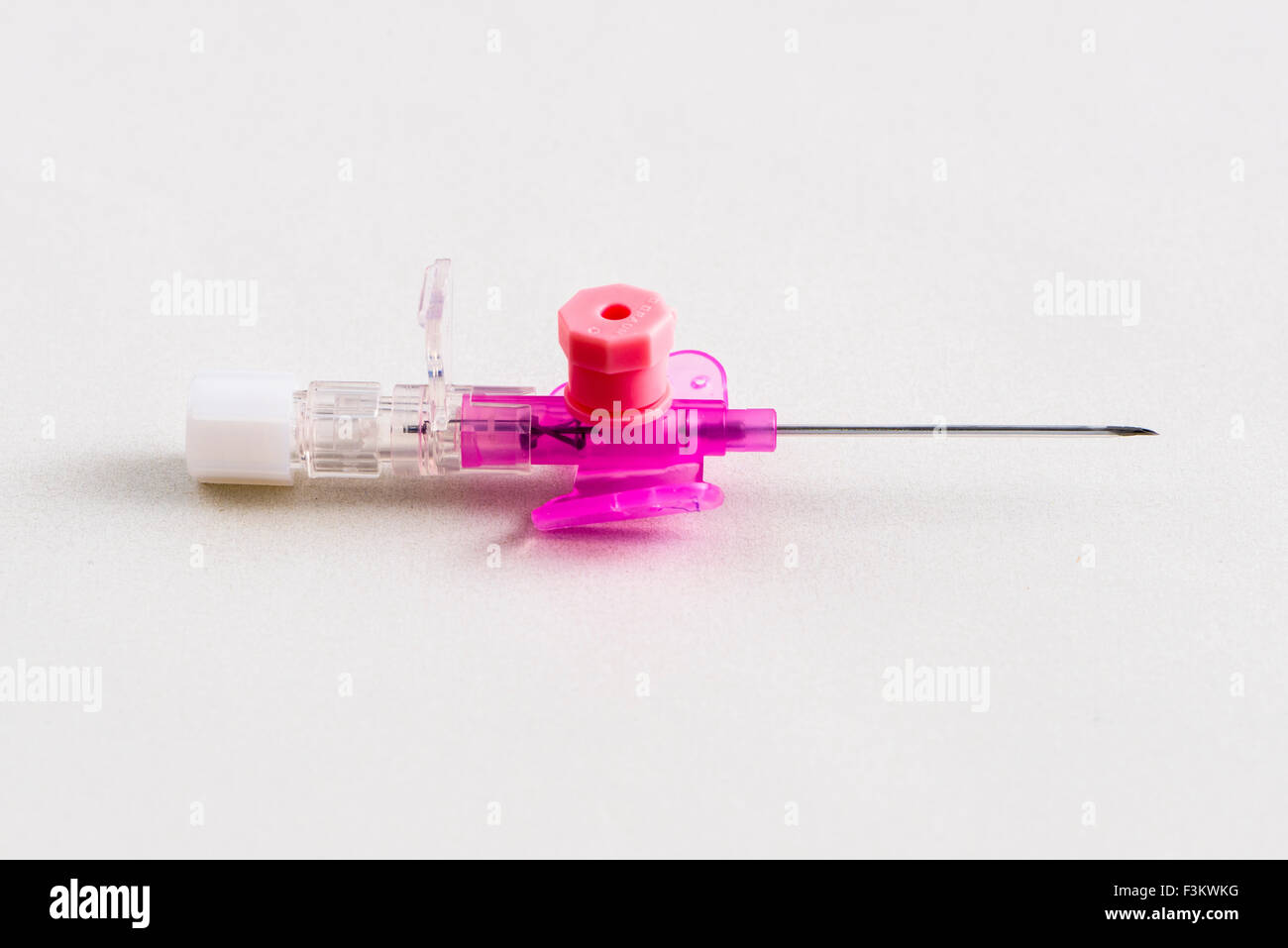 Una sicurezza rosa catetere iv con porta di iniezione per uso medico, visualizzato su un tavolo bianco Foto Stock