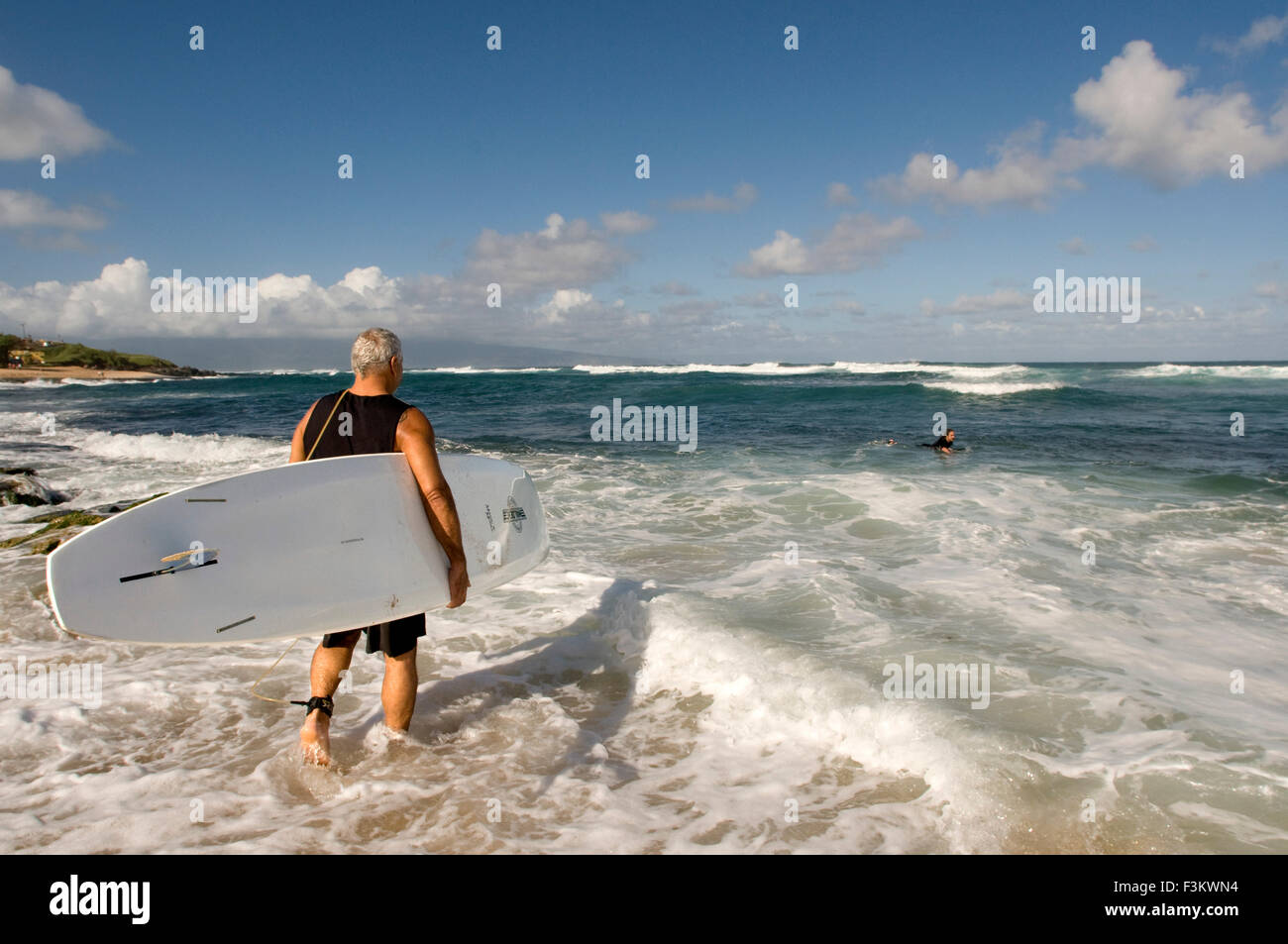 L'uomo Surfer andare all'acqua. Ho'okipa Beach. Maui. Hawaii. Uno dei migliori del mondo windsurf spiagge, Hookipa è anche un favorit Foto Stock